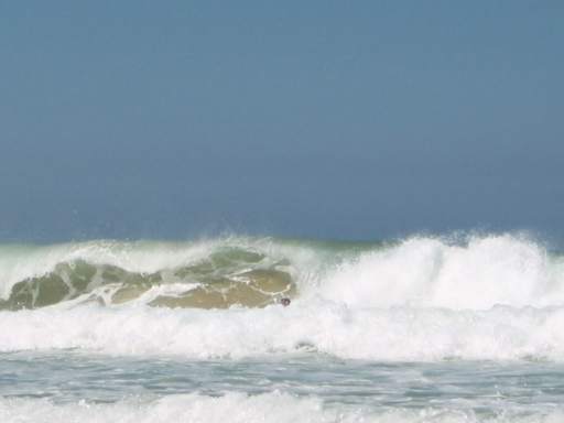 Welle reist Sand hoch